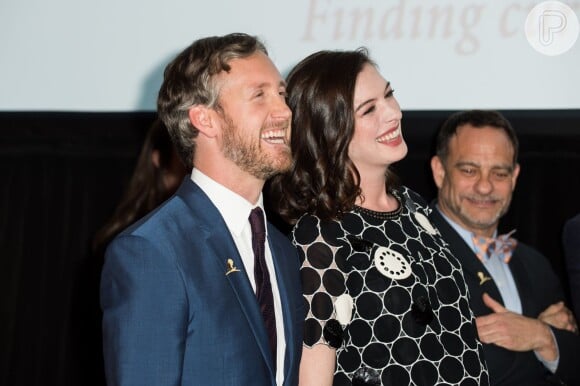 Anne Hathaway sorri ao lado do marido, Adam Shulman.