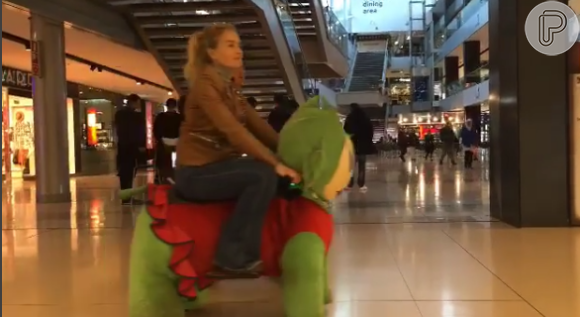 Angélica brinca no carrinho de pelúcia em um shopping na Europa