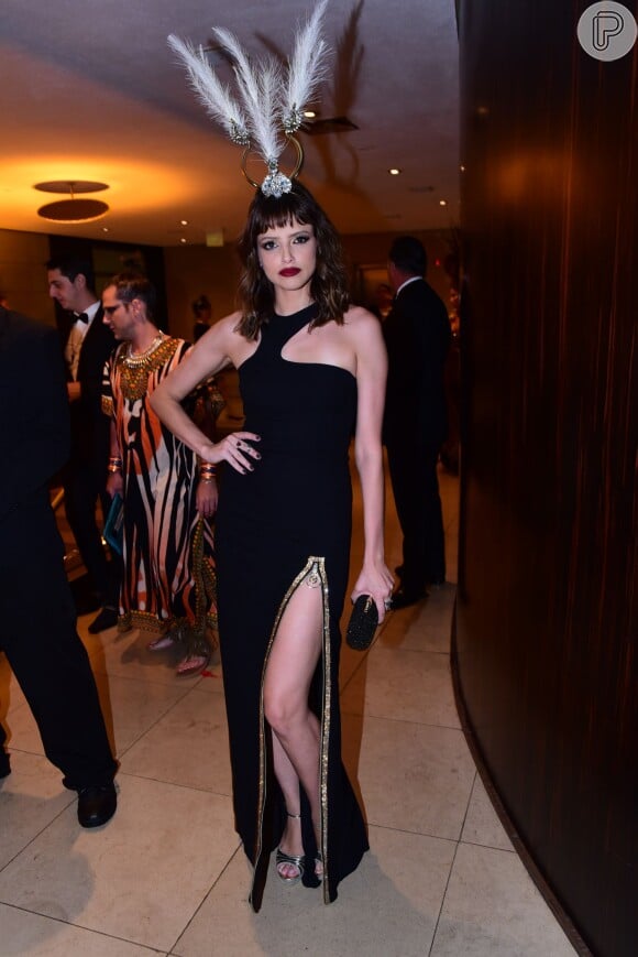 Agatha Moreira escolheu vestido preto fendado da Versace, com brincos de esmeralda e rubi e enfeite de cabeça com plumas para o Baile da Vogue 2016