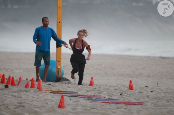 Até na hora de se exercitar Carolina Dieckmann procura realizar as atividades na praia. A atriz conta com a ajuda de um treinador para fazer exercícios de circuito