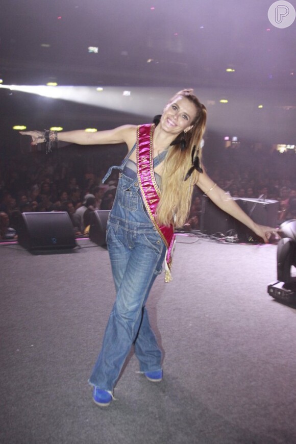 Carolina Dieckmann mais uma vez aparece com o macacão jeans, desta vez em um evento de carnaval, ao receber a faixa de madrinha do bloco da amiga Preta Gil, em fevereiro deste ano, no Barra Music