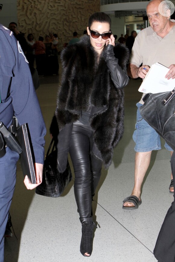 Kim Kardashian, desembarca, falando ao celular, no aeroporto de Miami em 12 de novembro de 2012