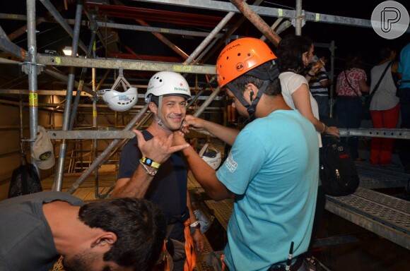 Malvino Salvador acena para o fotógrafo e coloca o capacete para anadra na tirolesa no Rock in Rio
