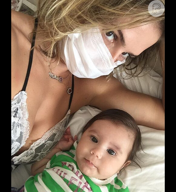 Deborah Secco usa máscara para proteger Maria Flor de gripe e internauta critica: 'Fresca'. Post foi feito nesta segunda-feira, 14 de março de 2016