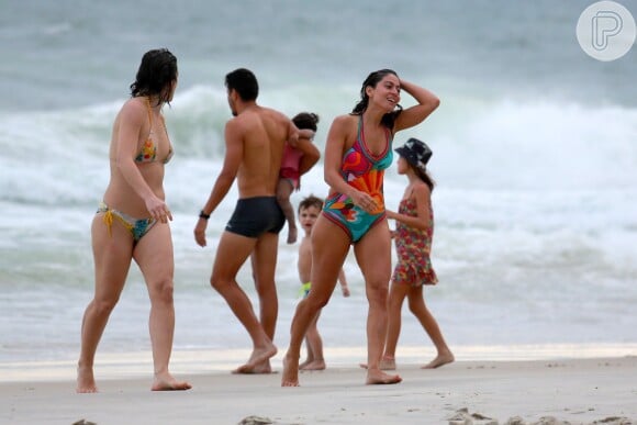 Carol Castro sai do mar acompanhada de amiga na praia da Joatinga