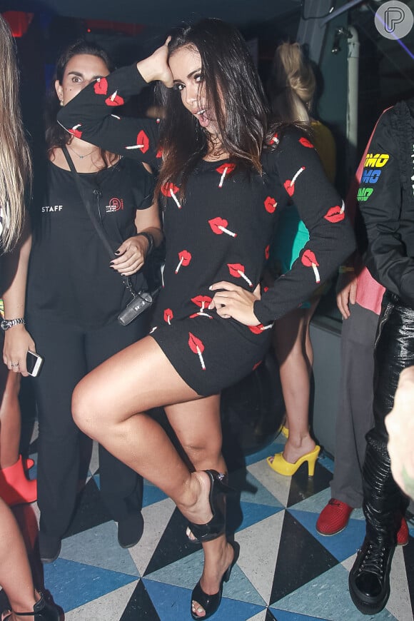 Anitta usou um vestido preto justinho com estampa de boca em evento de moda
