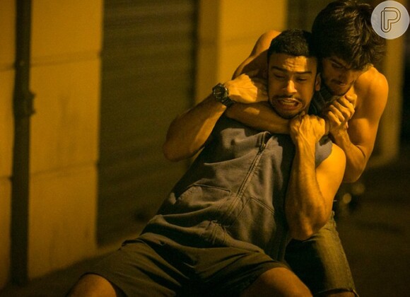 Jonatas (Felipe Simas) aproveita uma distração, desarma Jacaré (Sergio Malheiros) e os dois começam uma briga corporal, na novela 'Totalmente Demais'