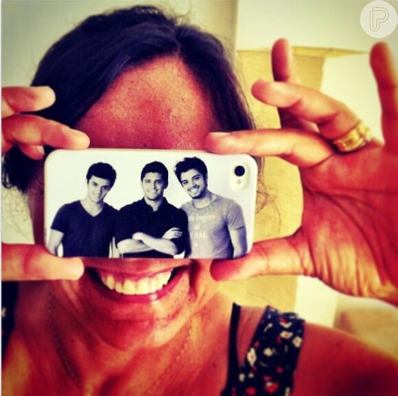 Ana Sang exibe orgulhosa a capinha de seu celular com a foto dos filhos: Felipe, Bruno e Rodrigo