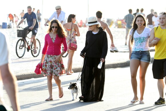 Bárbara Paz caminha na orla carioca com look preto
