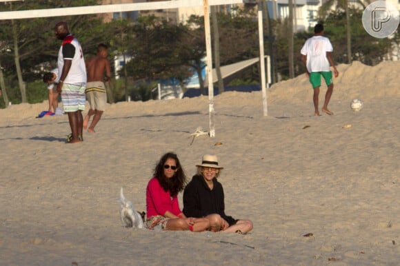 Bárbara Paz senta na areia da praia do Leblon, na Zona Sul do Rio