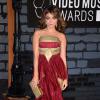 Sarah Hyland foi ao MTV Video Music Awards 2013, em Nova York, com um vestido vinho com detalhes em dourado. A atriz é boa em combinar os acessórios com a roupa e dessa vez não foi diferente: brincos e bolsa em harmonia com o vestido