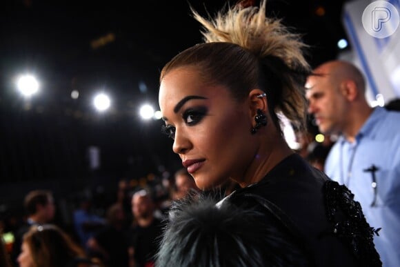 Na maquiagem, Rita Ora investiu em um visual rocker com olhos esfumados de preto e batom rosa nude