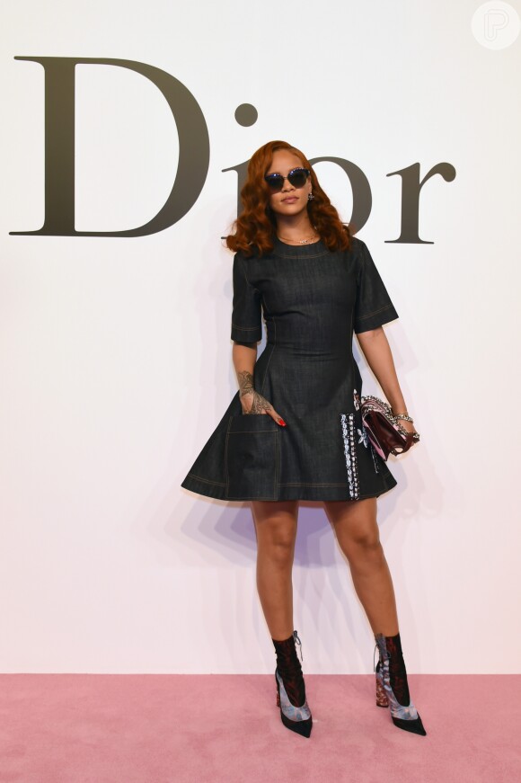 A cantora Rihanna usou um vestido jeans com lavagem escura e destacou o visual com unhas coloridas e bolsa em tom vibrante