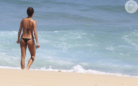 Para se refrescar, a ex-mulher de Paulinho Vilhena foi até o mar, mas preferiu molhar o corpo parcialmente
