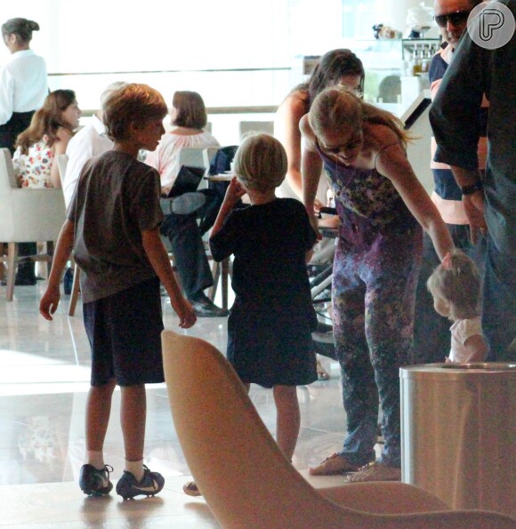 Joaquim, o mais velho dos três filhos de Angélica e Huck, observa os irmãos durante passeio no shopping