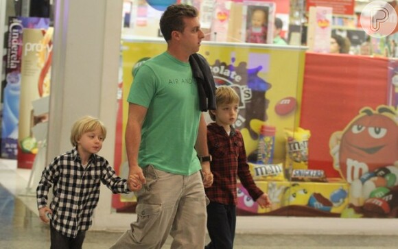 Joaquim, de blusa vermelha, em mais um passeio no shopping, desta vez apenas com o pai, Luciano Huck, e o irmão, Benício
