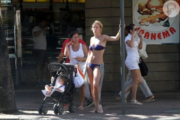 Letícia fica na sombra da calçada com babá e filho