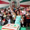 Laryssa posa atrás do bolo e com os integrantes da escola que será destaque no Carnaval 2013