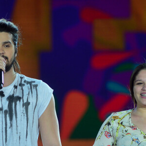 Luan Santana canta ao lado de fã em palco de festival