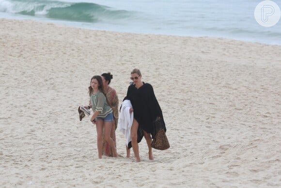 Kate Moss leva toalha nas mãos na saída da praia do Arpoardor no Rio de Janeiro; modelo está no Brasil para um evento em São Paulo