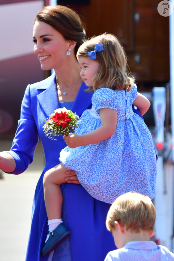 De vestido floral e laço no cabelo, Charlotte esbanjou fofura no colo de Kate Middleton ao chegar em Berlim, na Alemanha, nesta quarta-feira, em 19 de julho de 2017