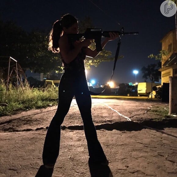 Bibi (Juliana Paes) se exibe com uma arma e se dispõe a buscar um carregamento de armas com um contato de Rubinho (Emílio Dantas), na novela 'A Força do Querer'