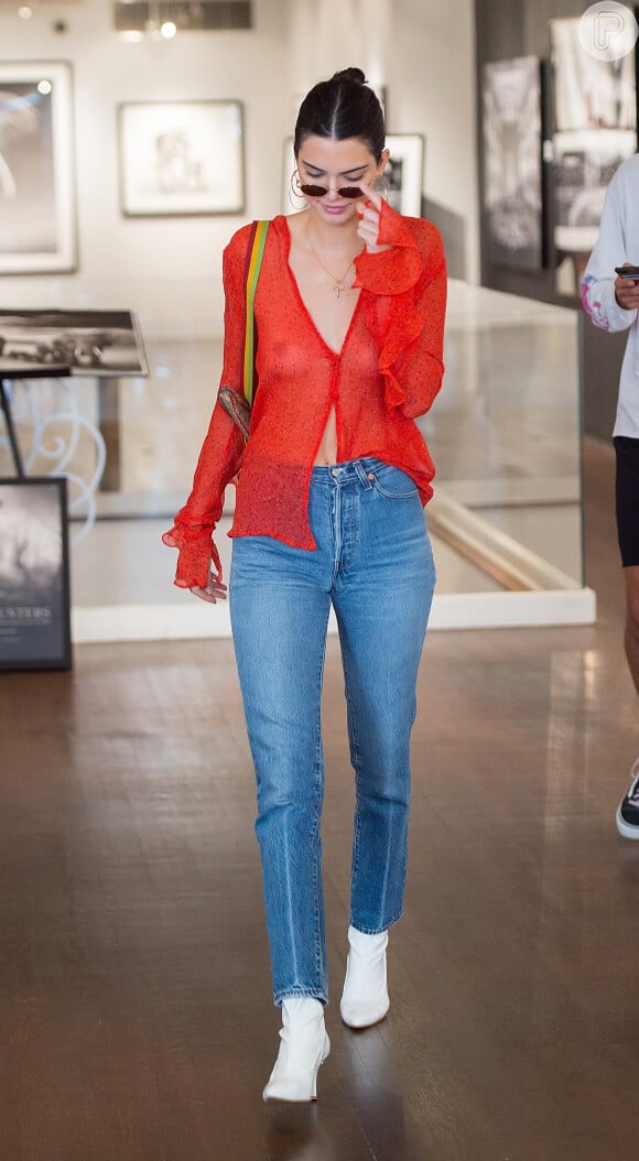 Em Nova York, Kendall Jenner combinou a blusa transparente com jeans de cintura alta, botas brancas e bolsa vintage Christian Dior