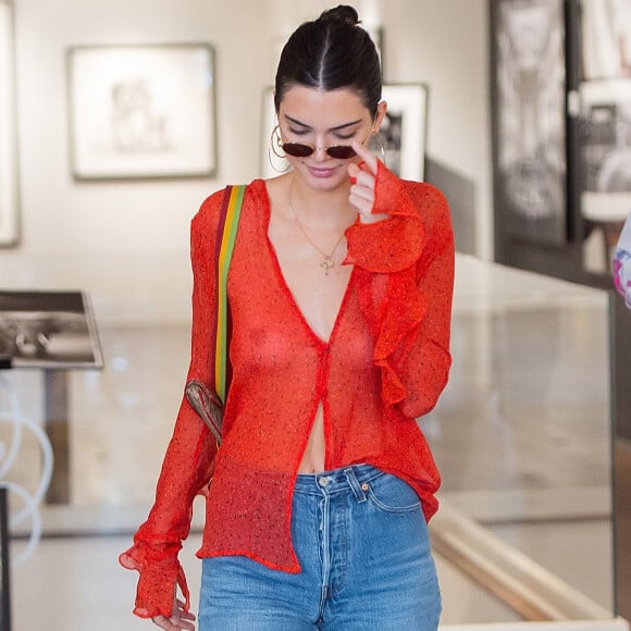 Em Nova York, Kendall Jenner combinou a blusa transparente com jeans de cintura alta, botas brancas e bolsa vintage Christian Dior