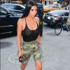 Kim Kardashian combinou a peça transparente com bermudas camufladas e sandálias prateadas