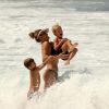 Fernanda Lima toma banho no mar com os dois filhos gêmeos, João e Francisco