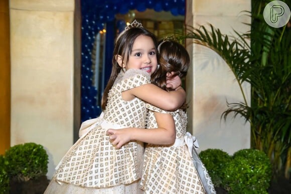 Maya e Kiara se abraçam durante a festa de aniversário de quatro anos