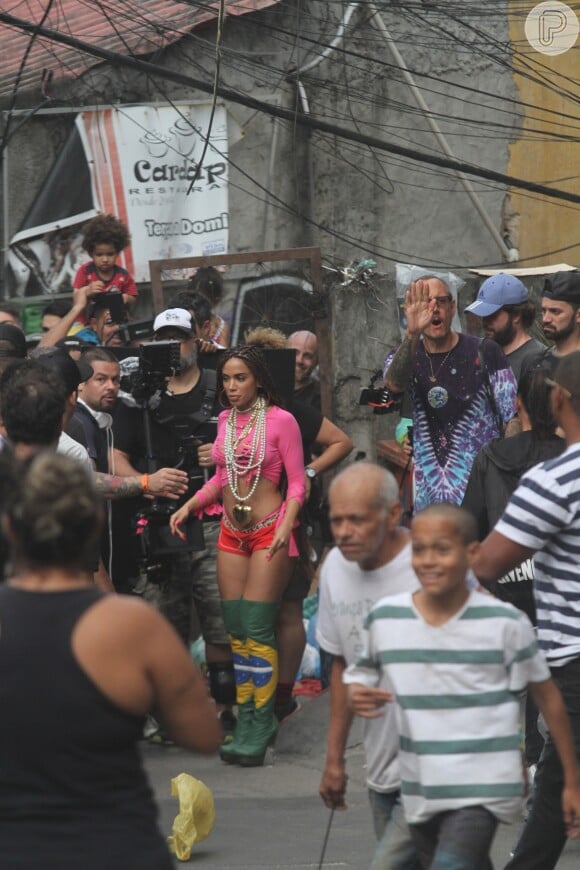 Usando botas de over the knee com cores da bandeira do brasil, minishorts e cropped em tons vibrantes, Anitta atraiu os olhares