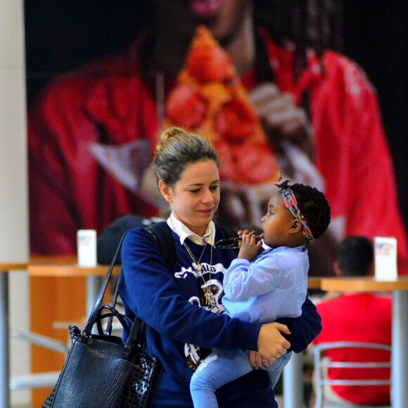 Leandra Leal leva a filha, Julia, no colo ao embarcar no Rio de Janeiro