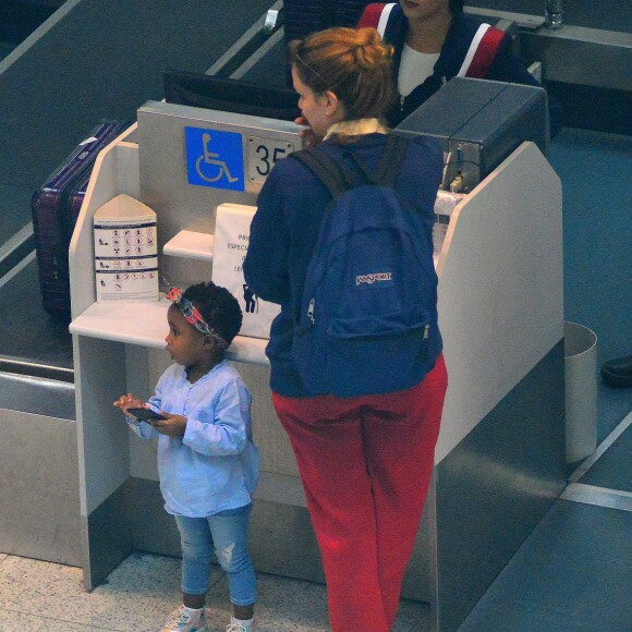 Leandra Leal é atendida no guichê de check in ao lado da filha, Julia