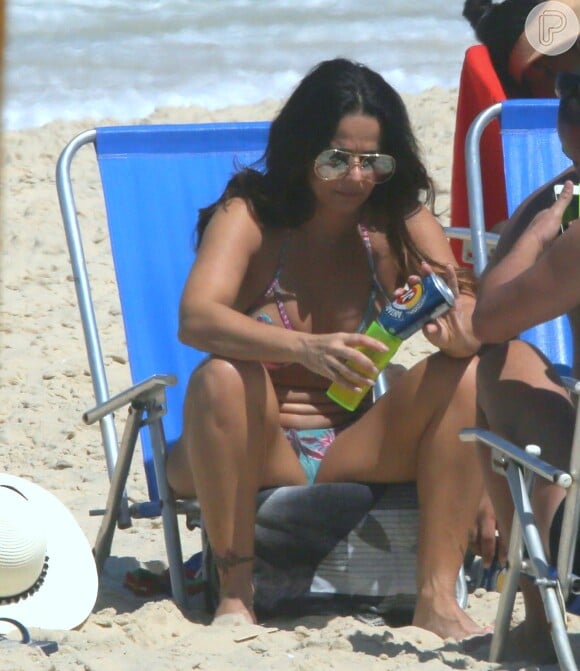 Acompanhada de amigos, Viviane Araujo tomou cerveja em praia do Rio