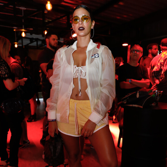 Bruna Marquezine usou top e tênis Puma, casaco transparente Fila e óculos com lentes amarelas no no Rock in Rio, em 16 de setembro de 2017