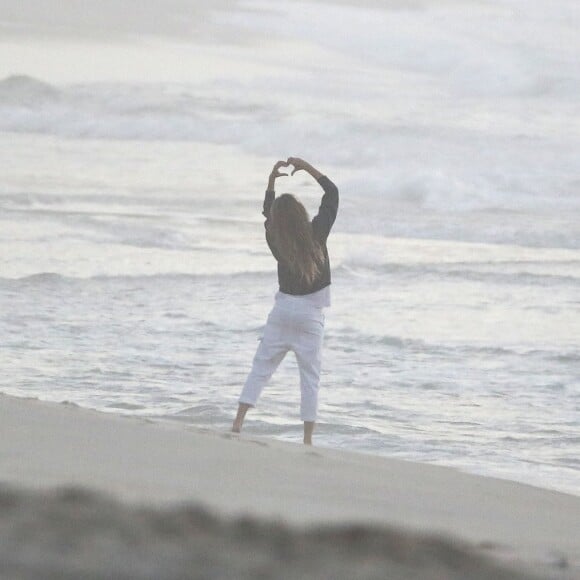 Gisele Bündchen faz pose com a mão em formato de coração em foto