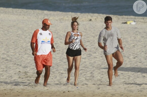 Danielle Winits treina com o namorado, Amaury Nunes, na praia da Barra da Tijuca, zona oeste do Rio de Janeiro, em 24 de janeiro de 2013