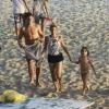 Danielle Winits deixa a praia com o filho e o namorado