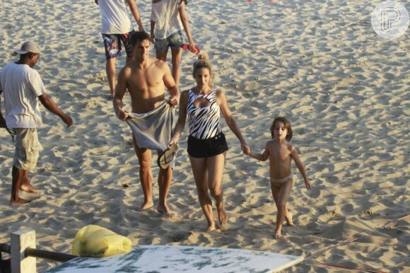 Danielle Winits deixa a praia com o filho e o namorado