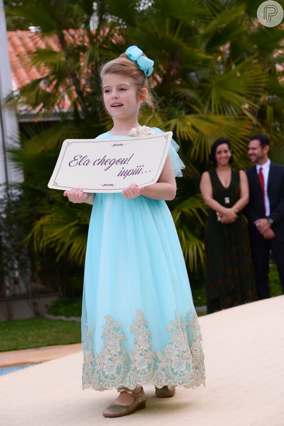 A pequena Dulce Maria (Lorena Queiroz), depois de ser arrumada por Cecília (Bia Arantes) leva uma plaquinha para anunciar a entrada de Tia Perucas (Priscila Sol), na novela 'Carinha de Anjo'
