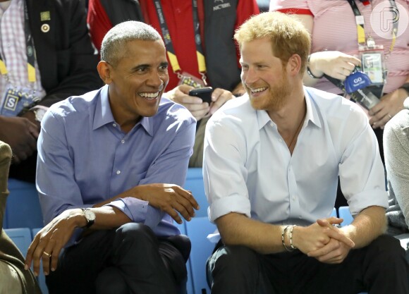 Príncipe Harry ri ao conversar com Barack Obama