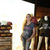 Sorridente Avril Lavigne conheceu a loja e na saída acenou para os fãs que tiravam fotos da artista no corredor do shopping
