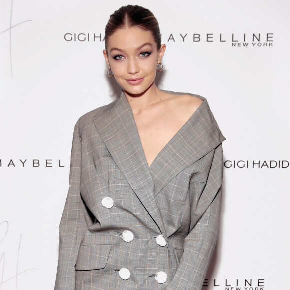 Gigi Hadid, sem sutiã, deixou o ombro à mostra com o blazer vestido Carmen March, coleção outono 2017