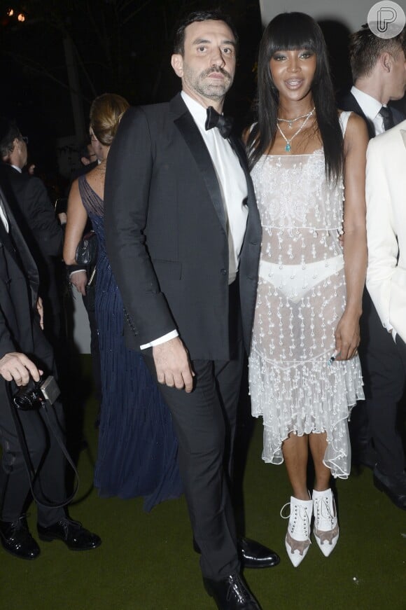 Pouco mais de duas décadas após a festa em Londres, Naomi Campbell exibiu um look supertransparente, deixando a calcinha branca em evidência, ao posar com o estilista Riccardo Tisci no baile de gala da amfAR, realizado em São Paulo, em 15 de abril de 2016