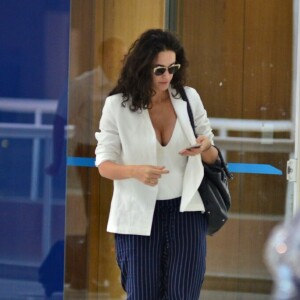 Sem salto, Debora Nascimento combinou sapato, blazer e blusa branca com uma calça azul com risca de giz, de modelagem ampla