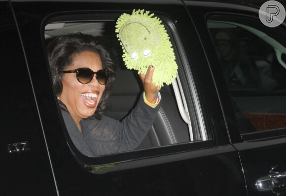 Sempre muito bem humorada, ao entrar no carro, Oprah tirou as pantufas e as mostrou para os fotógrafos de plantão