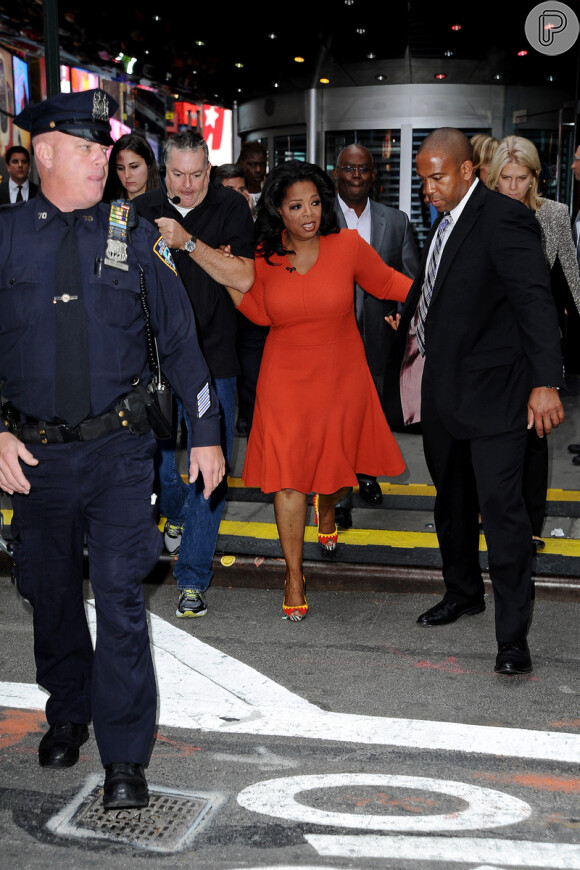 Antes de aparecer com o look confortável, Oprah usava um belo vestido vermelho