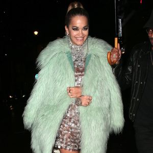 Para se proteger do frio de Londres, Rita Ora sobrepôs o vestido de paetês com um casaco de pelos verde