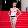 Adriana Lima chegou ao red carpet no Festival de Cannes roubando a cena; modelo apareceu com vestido de corte generoso que deixou as pernas à mostra